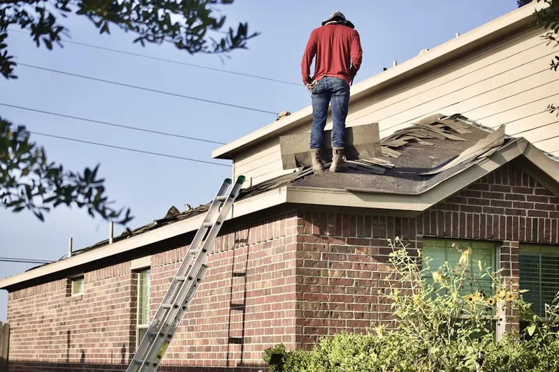 Professional roofer working on a residential roof in Newton Lower Falls